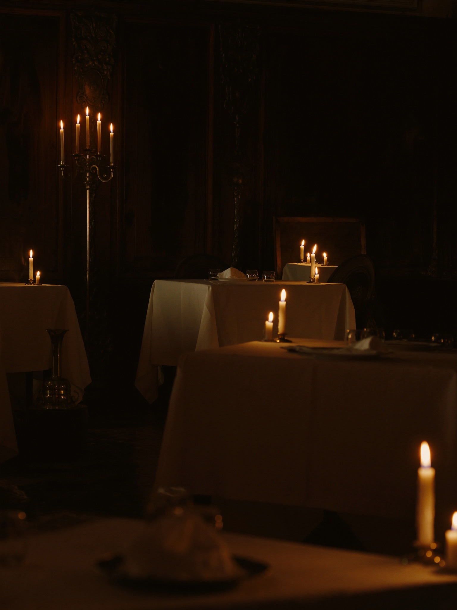 Candle-lit dining room with linen tables