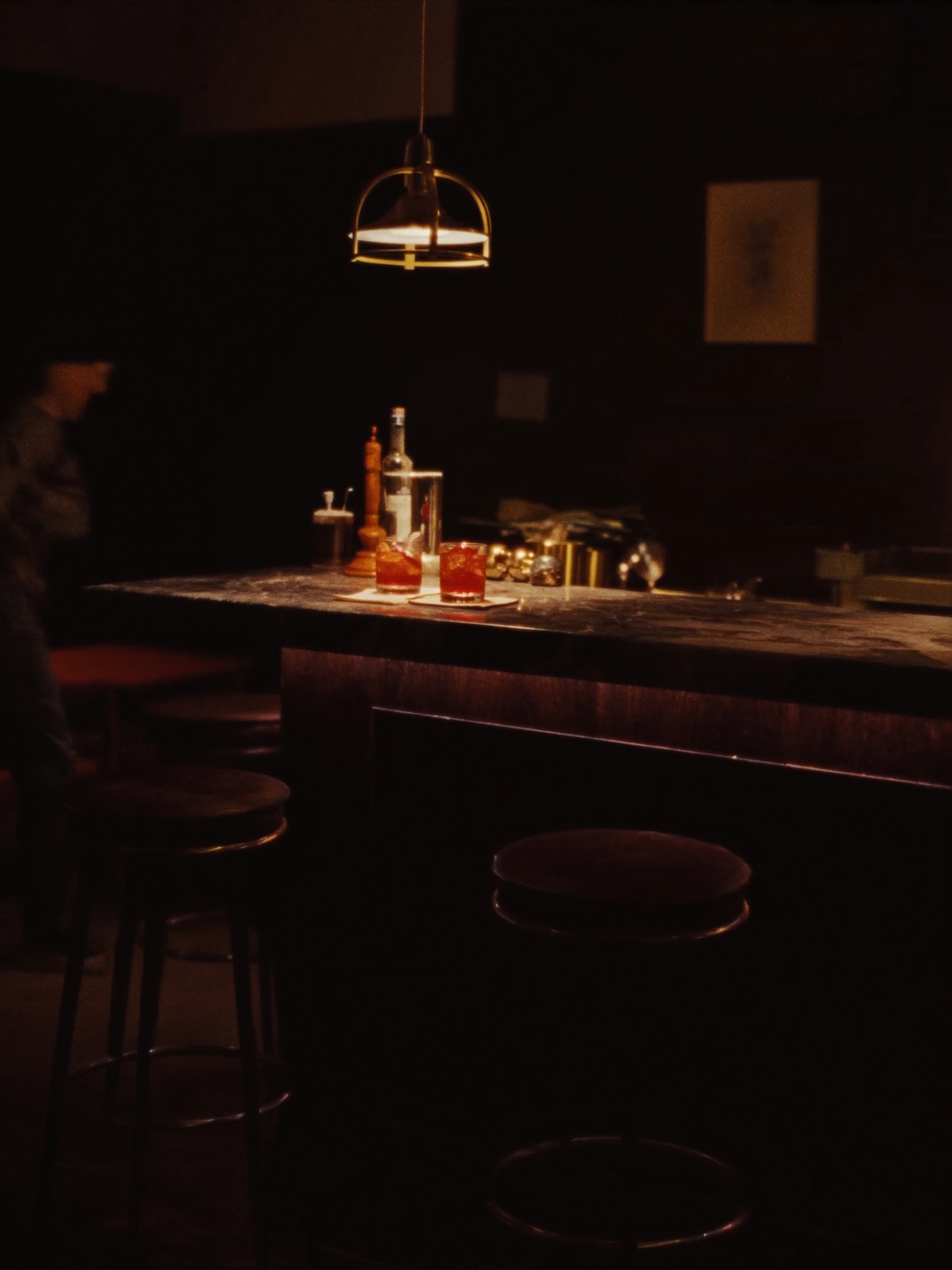 Guests at the bar under warm pendant light
